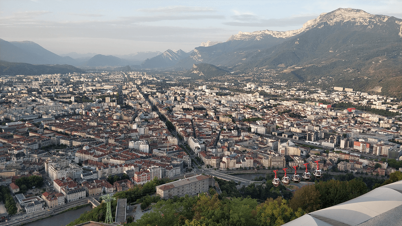 A view of Grenoble surrounded by mountains, taken from the Bastille.